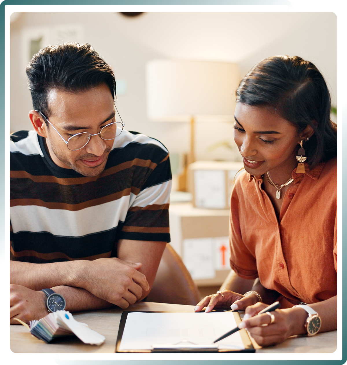 Two people reviewing documents together at desk.