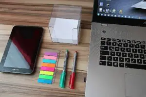 Office supplies and laptop on wooden desk.
